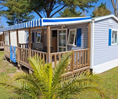 Terrasse de mobil-home avec store rayé au Camping La Prévoté