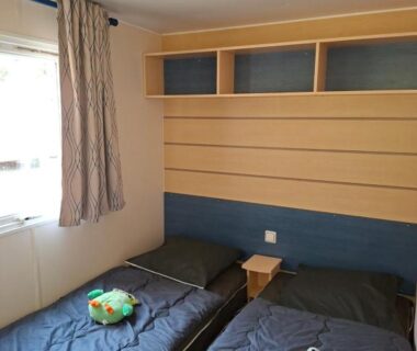 Chambre avec deux lits simples et peluches dans le locatif du Camping La Prévoté