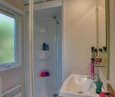 Salle de bain avec douche et lavabo dans l'hébergement du Camping La Sagne
