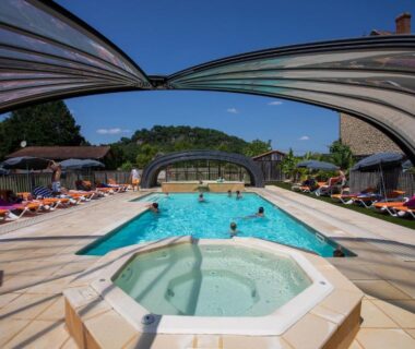 Piscine extérieure avec spa et pergolas sur terrasse au Camping La Sagne