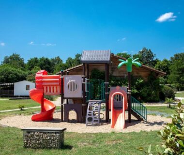 Aire de jeux avec toboggans et structures en bois au Camping La Sagne