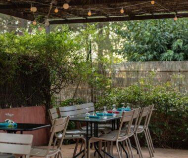 Terrasse ombragée avec tables et chaises au Camping La Tour de France