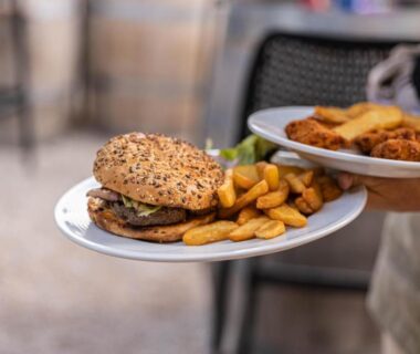 Terrasse extérieure avec burger et frites au Camping La Tour de France