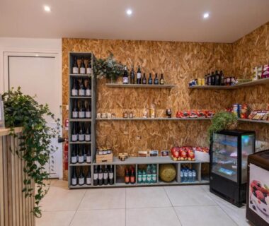 Boutique d'accueil avec étagères de boissons et snacks au Camping La Tour de France