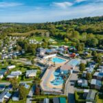 Aire de piscine centrale avec bassins et mobil-homes au Camping La Vallée