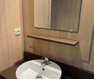 Salle de bain avec lavabo rond et miroir dans l'hébergement du Camping La Venise Du Bocage