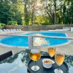 Au bord de la piscine avec verres de bière et coupelle de noix au Camping La sablière