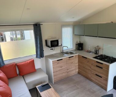 Intérieur mobil-home coin salon et kitchenette du Camping La sablière