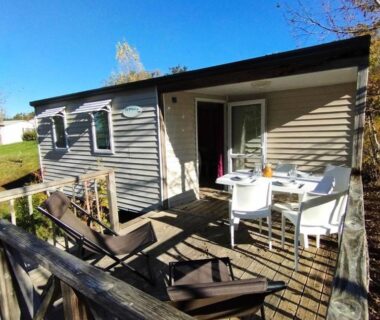 Terrasse en bois avec table chaises et transats du mobil-home Camping Lac aux Oiseaux MAE-0991