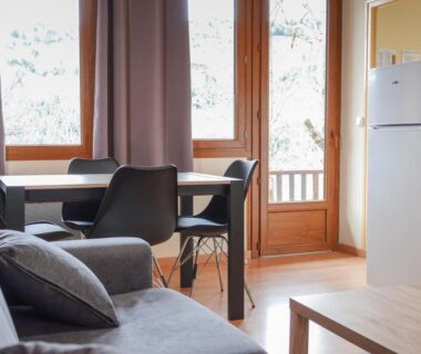 Intérieur avec canapé et table à manger du Camping Lac de Villefort
