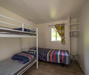 Chambre avec lits superposés et lit simple au Camping Le Barutel