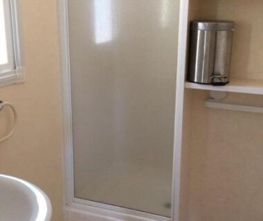 Salle de bain avec douche cabine et lavabo au Camping Le Bois De Pins