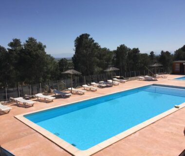 Piscine extérieure avec transats et parasols au Camping Le Bois De Pins