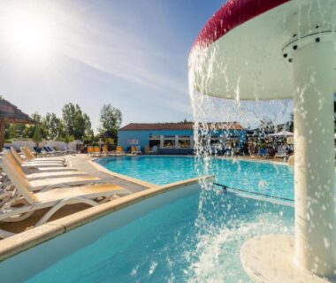 Piscine extérieure avec fontaine et transats au Camping Le Bois Soleil Mobil home 3 pièces 4 personnes