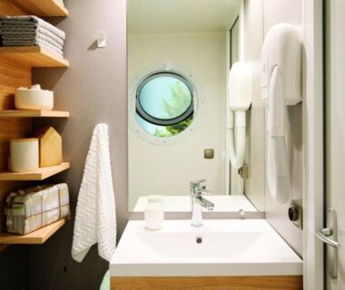 Salle de bain compacte avec lavabo et hublot au Camping Le Bois Verdon