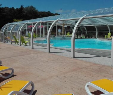 Piscine couverte avec transats sur terrasse au Camping Le Bois Verdon