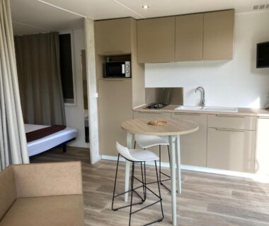Cuisine ouverte avec table et coin nuit dans le Camping Le Bon Coin Cottage 2 pers