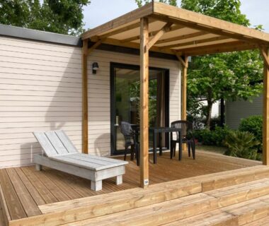 Terrasse en bois avec transat et table sur le Cottage 2 pers du Camping Le Bon Coin