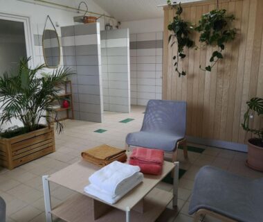 Salle de détente avec douches et transats au Camping Le Both d'Orouet
