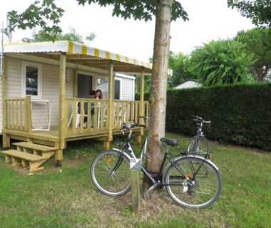 Emplacement herbeux avec mobil home terrasse et deux vélos du camping Le Both d'Orouet