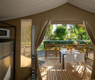 Terrasse en bois avec table et chaises depuis la tente au Camping Le Both d'Orouet