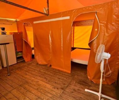 Intérieur de tente avec kitchenette et lits superposés au Camping Le Bourdieu