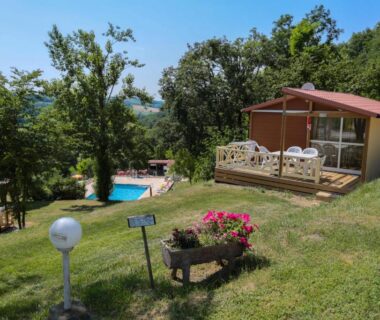 Terrasse en bois avec chaises et petite piscine au Camping Le Bourdieu