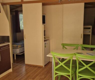 Intérieur avec kitchenette et table verte dans le Camping Le Bourdieu