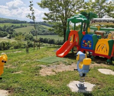 Aire de jeux extérieure avec toboggan et jouets à ressort dans le camping Le Bourdieu