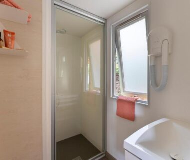 Salle de bain compacte avec douche et lavabo dans l'hébergement du Camping Le Calypso 5 étoiles