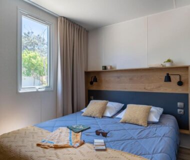 Chambre avec lit double et fenêtre au Camping Le Calypso 5 étoiles