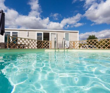 Piscine devant mobil-home et terrasse au Camping Le Cardinal
