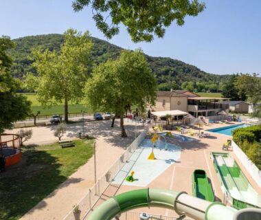 Piscine extérieure avec toboggans et solarium au Camping Le Chassezac