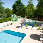 Piscine extérieure avec toboggan et transats au Camping Le Chassezac