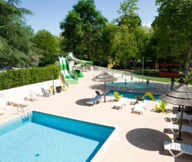 Piscine extérieure avec toboggan et transats au Camping Le Chassezac