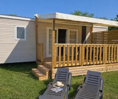 Terrasse en bois avec deux transats devant mobil home du Camping Le Chassezac