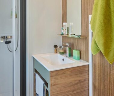 Salle de bains avec lavabo et douche dans le Camping Le Damier