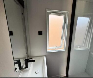 Salle de bains avec lavabo et cabine de douche dans le mobil home Le Hameau des Pins