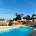 Piscine extérieure avec transats dans le camping Le Logis 3 étoiles