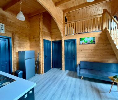 Intérieur en bois avec kitchenette canapé et mezzanine du Camping Le Logis 3 étoiles