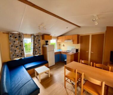 Salon avec kitchenette et banquette dans le mobil home du Camping Le Logis