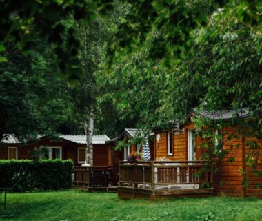 Chalets en bois avec terrasses dans un parc au Camping Le Malazéou Wellness Sport Camping