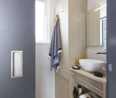 Salle de bains compacte avec lavabo et rangements au Camping Le Marqueval