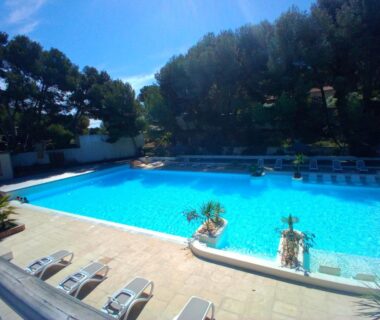 Piscine extérieure et transats au Camping Le Mas