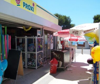 Façade de la boutique et articles de plage au Camping Le Mas