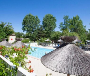 Espace piscine avec parasols et transats au Camping Le Mas de Reilhe
