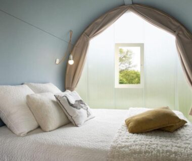 Intérieur de tente avec lit et petite fenêtre au Camping Le Mas de Reilhe