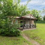 Terrasse ombragée et pelouse dans la nature au Camping Le Mont Libre Cottage et espace nature Gannat