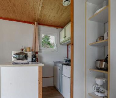 Cuisine équipée avec étagères et micro-ondes dans le cottage au Camping Le Mont Libre