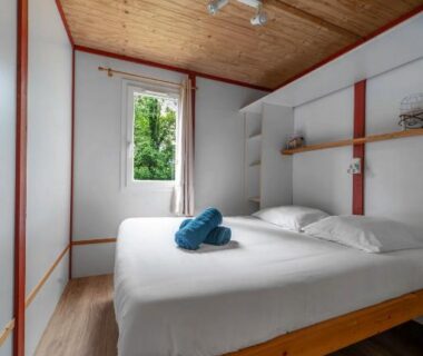 Intérieur de chambre avec lit double et fenêtre au Cottage Le Mont Libre